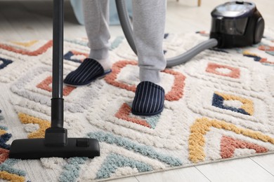 Photo of Man with vacuum cleaning carpet indoors, closeup