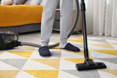 Photo of Man with vacuum cleaning carpet in bedroom, closeup