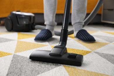 Photo of Man with vacuum cleaning carpet indoors, closeup