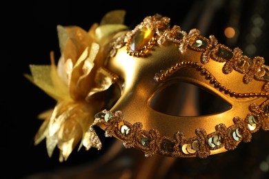 Beautiful golden carnival mask in darkness, closeup