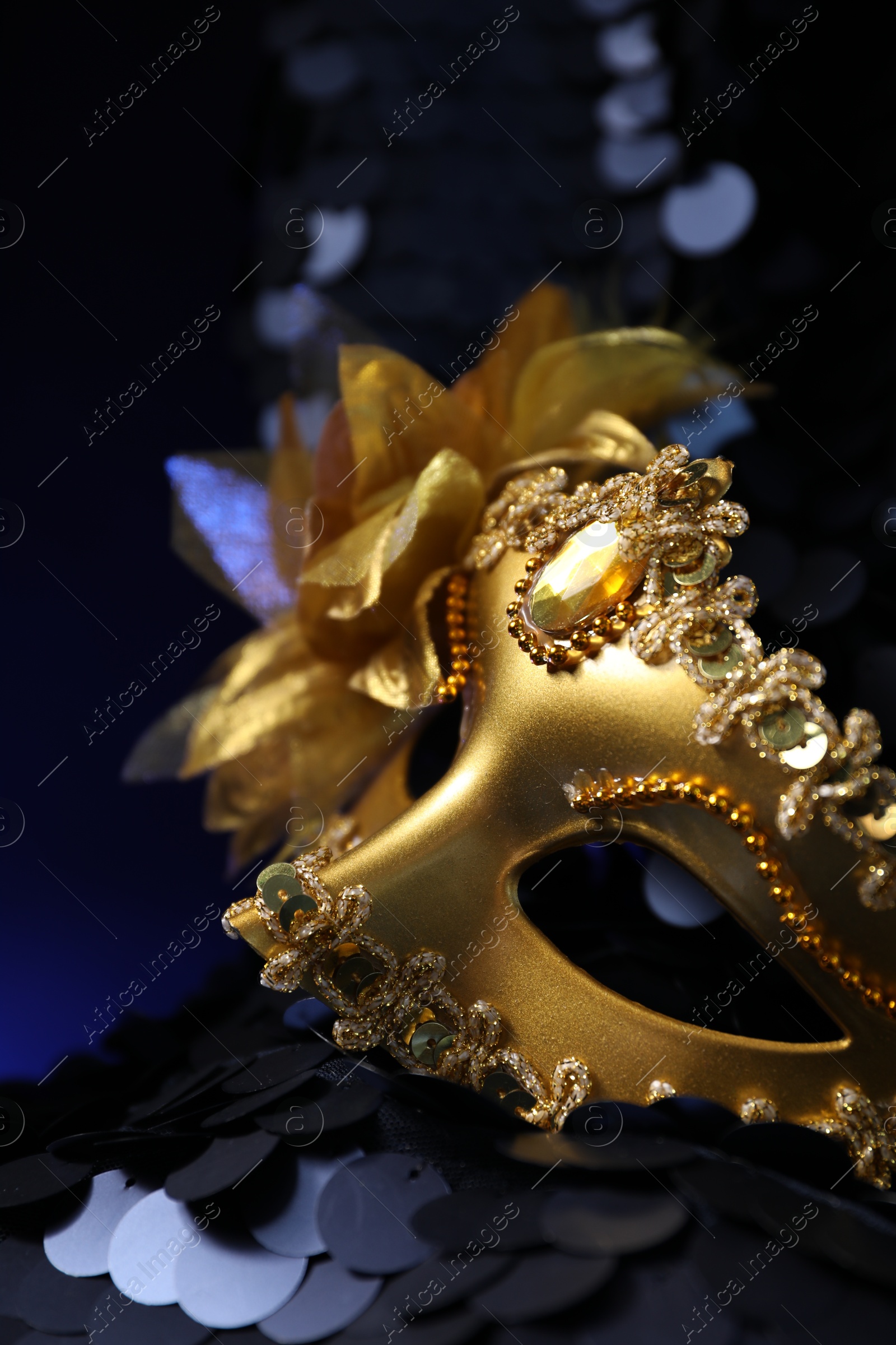 Photo of Beautiful golden carnival mask on dark blue background, closeup