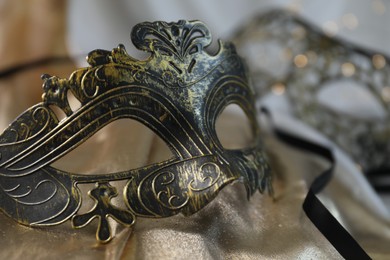 Beautiful carnival mask on golden fabric, closeup