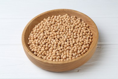 Dried peas in bowl on white wooden table, closeup