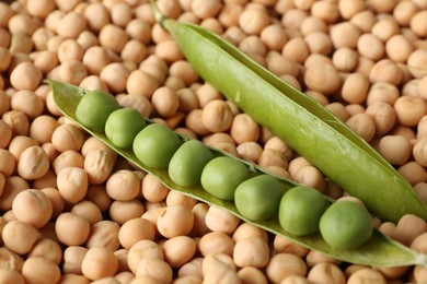 Photo of Fresh pods with peas on dried ones, closeup