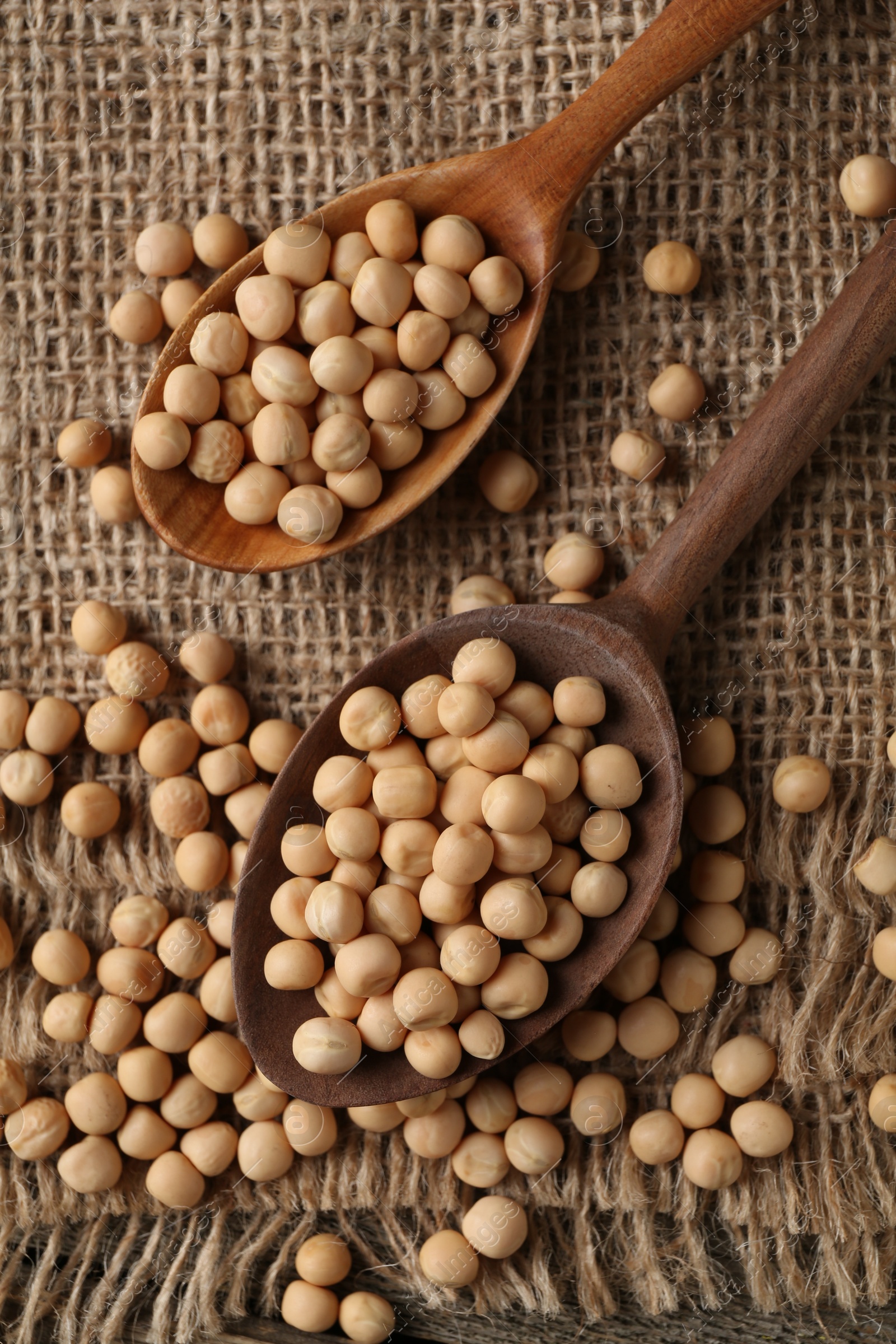 Photo of Spoons with dried peas on table, top view