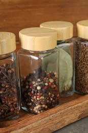 Photo of Different spices in glass jars on table, closeup