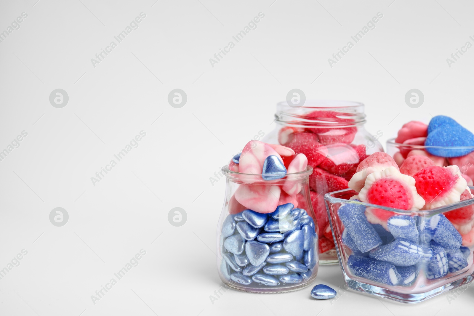 Image of Many bright candies in glass jars on light table. Space for text