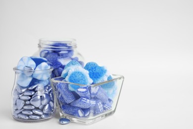 Image of Many blue color candies in glass jars on white background. Space for text