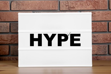 Image of Hype word on sheet of paper against brick wall