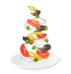 Fresh vegetables for salad falling onto plate on white background