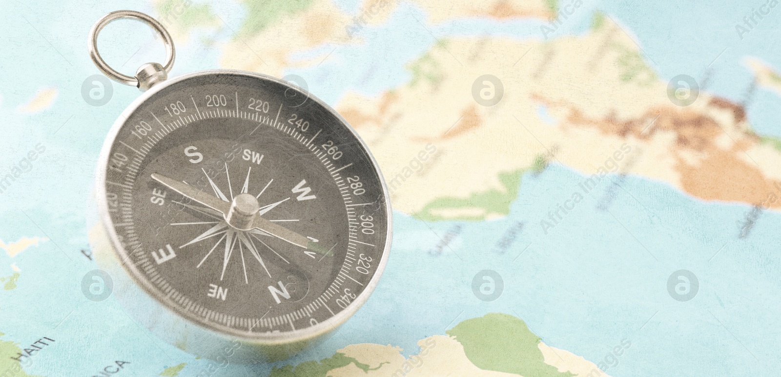 Image of Compass on world map, closeup. Banner design with space for text