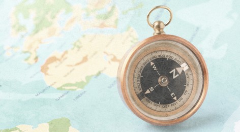 Image of Compass on world map, closeup. Banner design with space for text