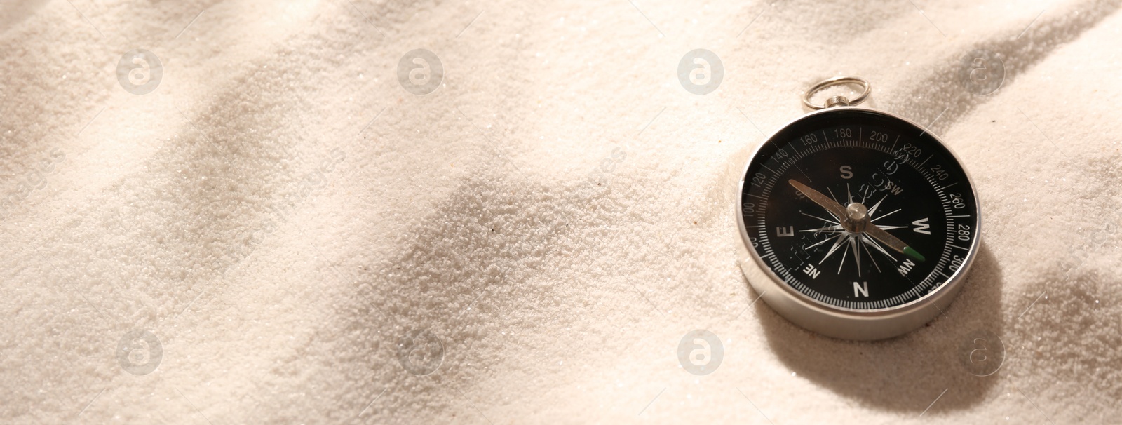 Image of Compass on sand. Banner design with space for text