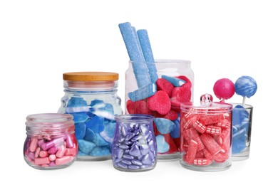 Many bright candies in glass jars on white background