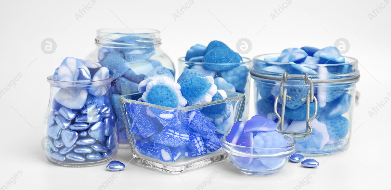 Image of Many blue color candies in glass jars on white background. Banner design