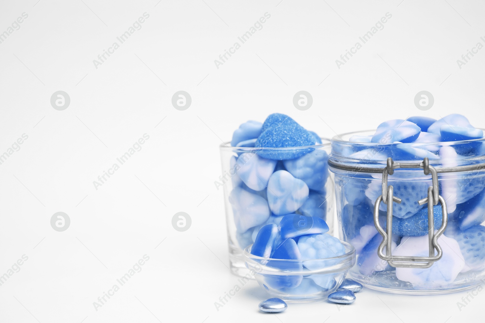 Image of Many blue color candies in glass jars on white background. Space for text