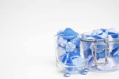 Image of Many blue color candies in glass jars on white background. Space for text