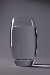 Photo of Glass of fresh water on grey background