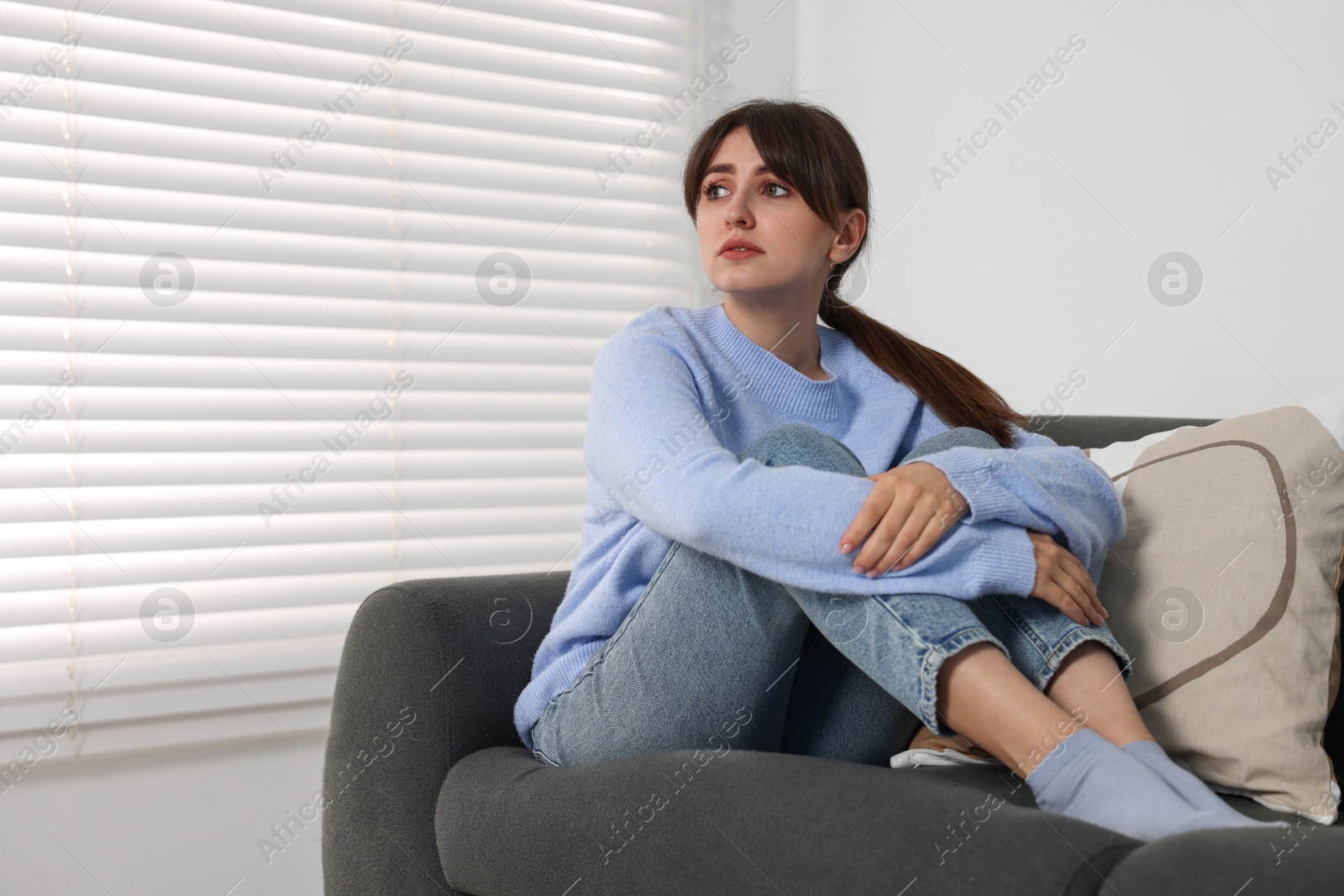 Photo of Loneliness concept. Sad woman sitting on sofa at home