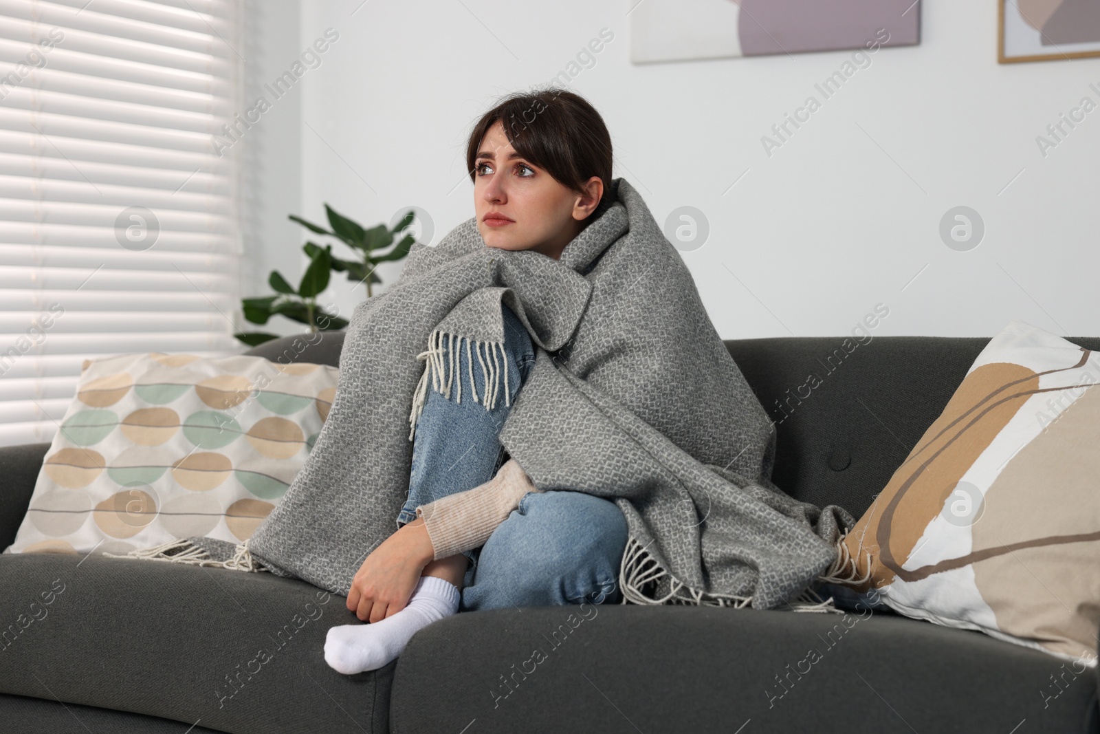 Photo of Loneliness concept. Sad woman sitting on sofa at home