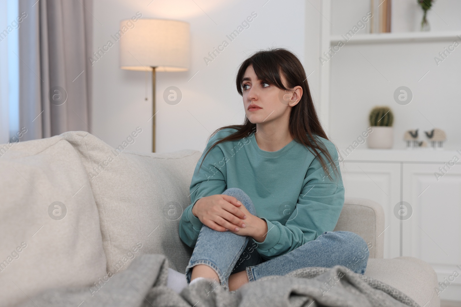 Photo of Loneliness concept. Sad woman sitting on sofa at home