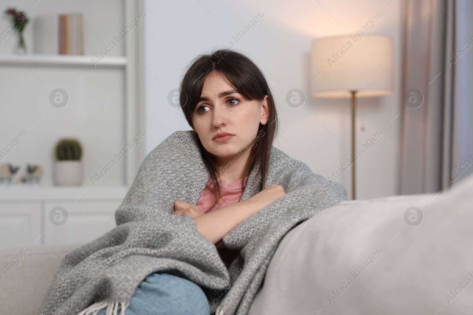 Photo of Loneliness concept. Sad woman sitting on sofa at home