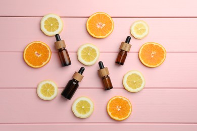 Photo of Aromatherapy. Different essential oils and citrus fruits on pink wooden table, flat lay