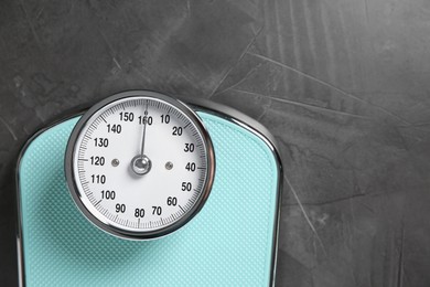 Photo of One bathroom scale on grey textured background, top view. Space for text