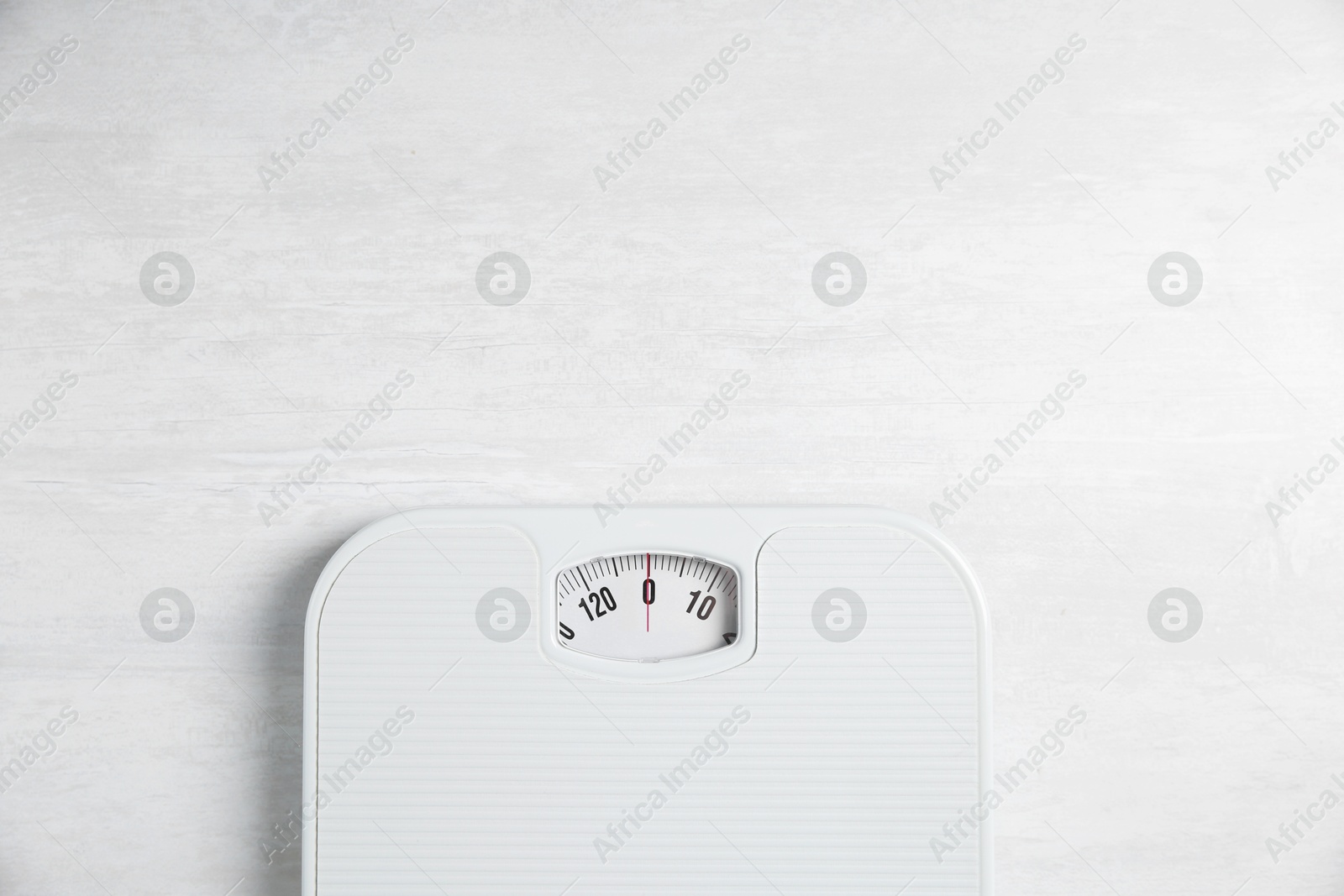 Photo of One bathroom scale on white wooden background, top view. Space for text