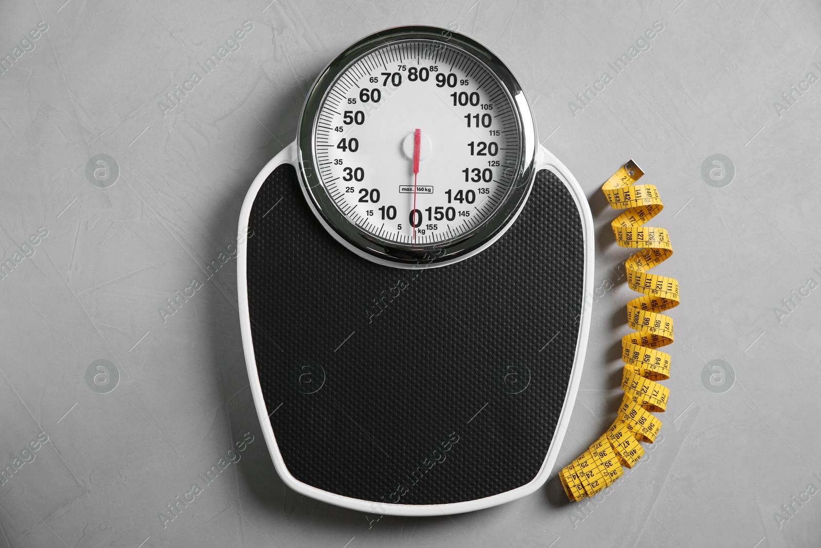 Photo of Scale and measuring tape on grey textured background, flat lay