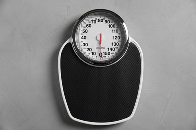 Photo of One bathroom scale on grey textured background, top view