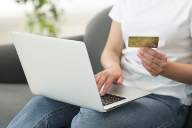 Photo of Online banking. Woman with credit card and laptop paying purchase at home, closeup