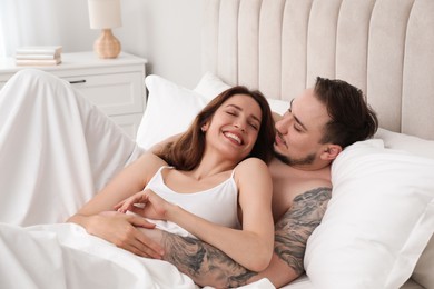 Photo of Lovely couple enjoying time together in bed at morning