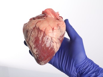 Photo of Doctor with heart on white background, closeup