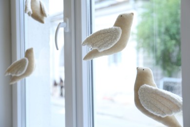 Photo of Beautiful handmade toy birds hanging near window