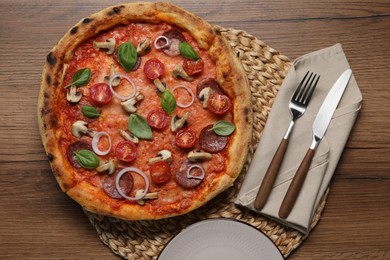 Photo of Delicious pizza with vegetables, salami, mushrooms and basil served on wooden table, flat lay