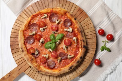 Photo of Delicious pizza with tomatoes, salami, mushrooms and basil on white wooden table, top view