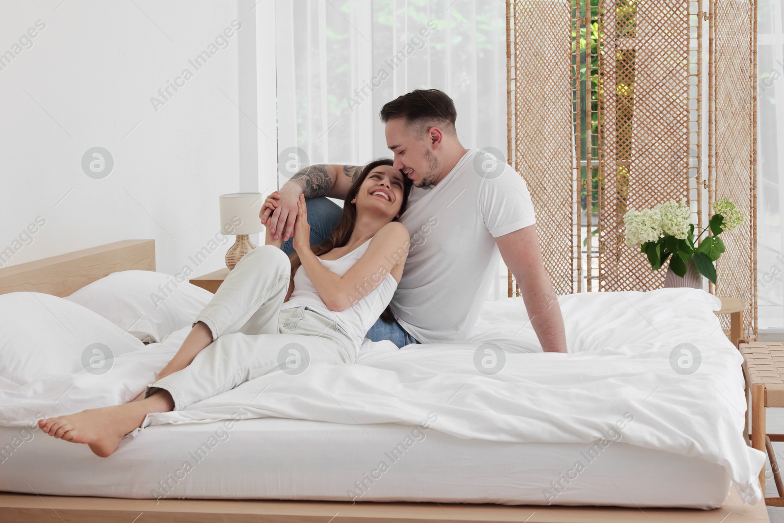 Photo of Lovely couple spending time together on bed at home