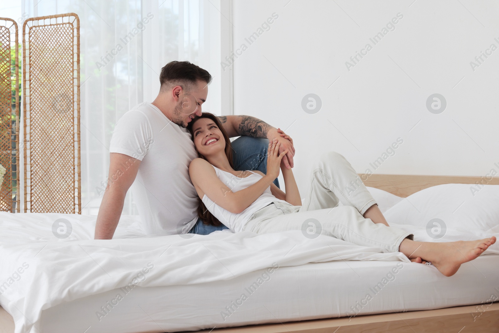 Photo of Lovely couple spending time together on bed at home