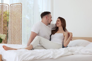 Photo of Lovely couple spending time together on bed at home