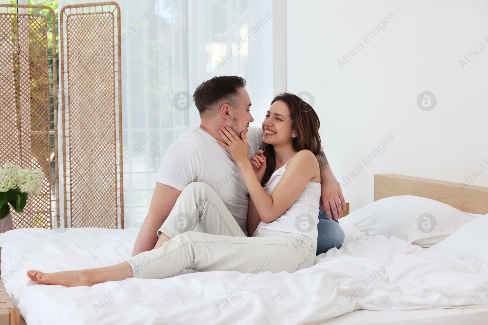 Photo of Lovely couple spending time together on bed at home