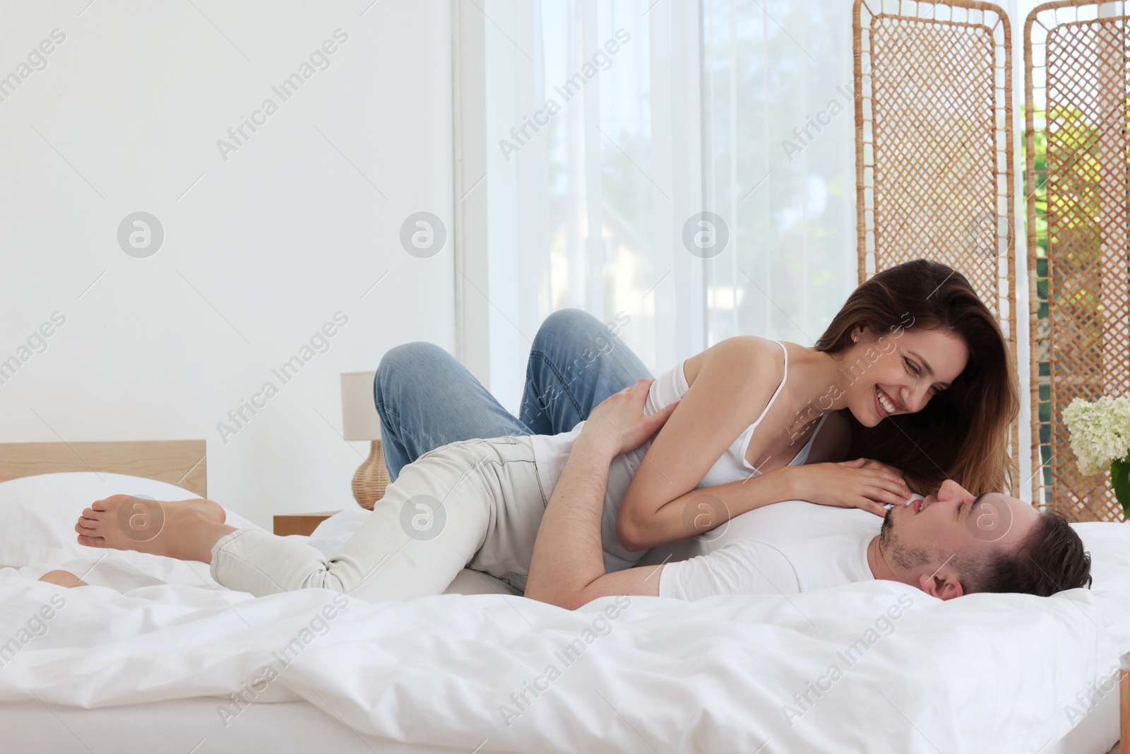 Photo of Lovely couple spending time together on bed at home