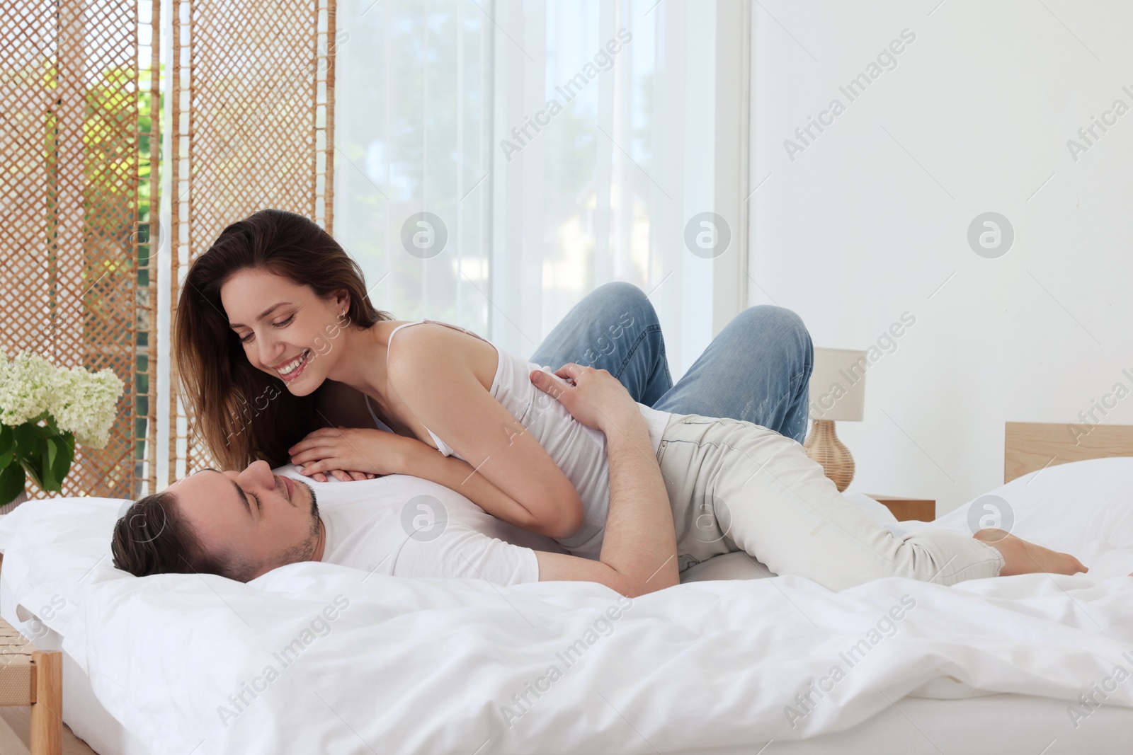 Photo of Lovely couple spending time together on bed at home