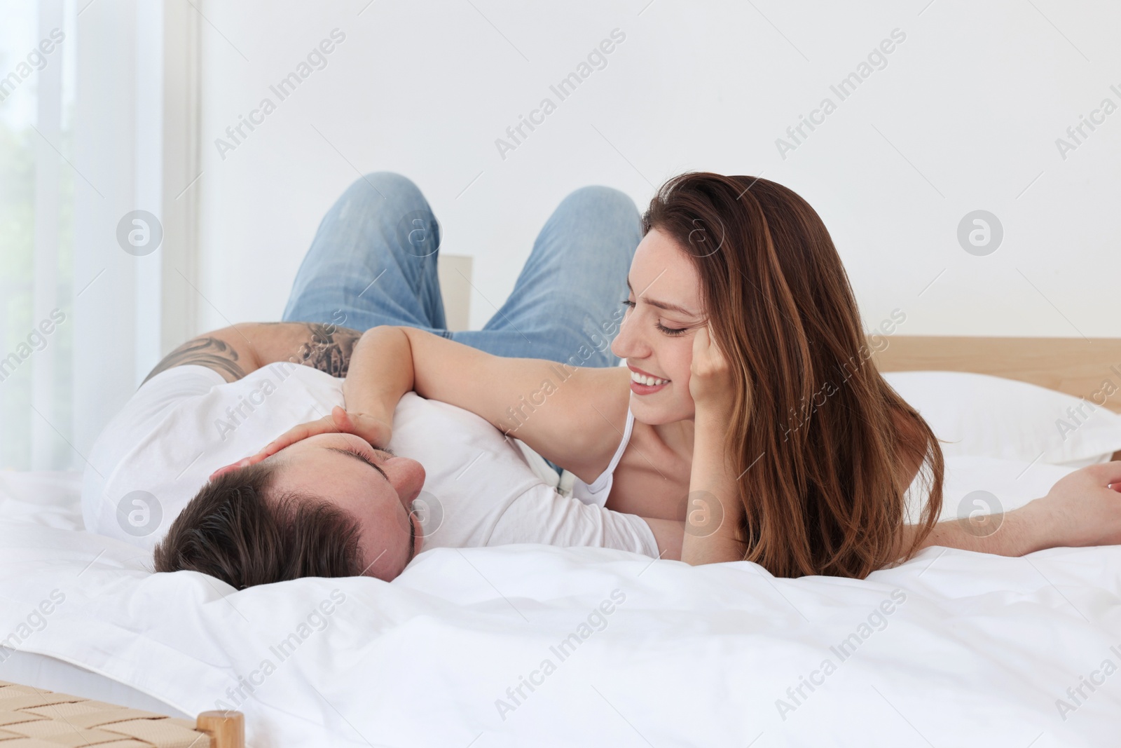 Photo of Lovely couple spending time together on bed at home