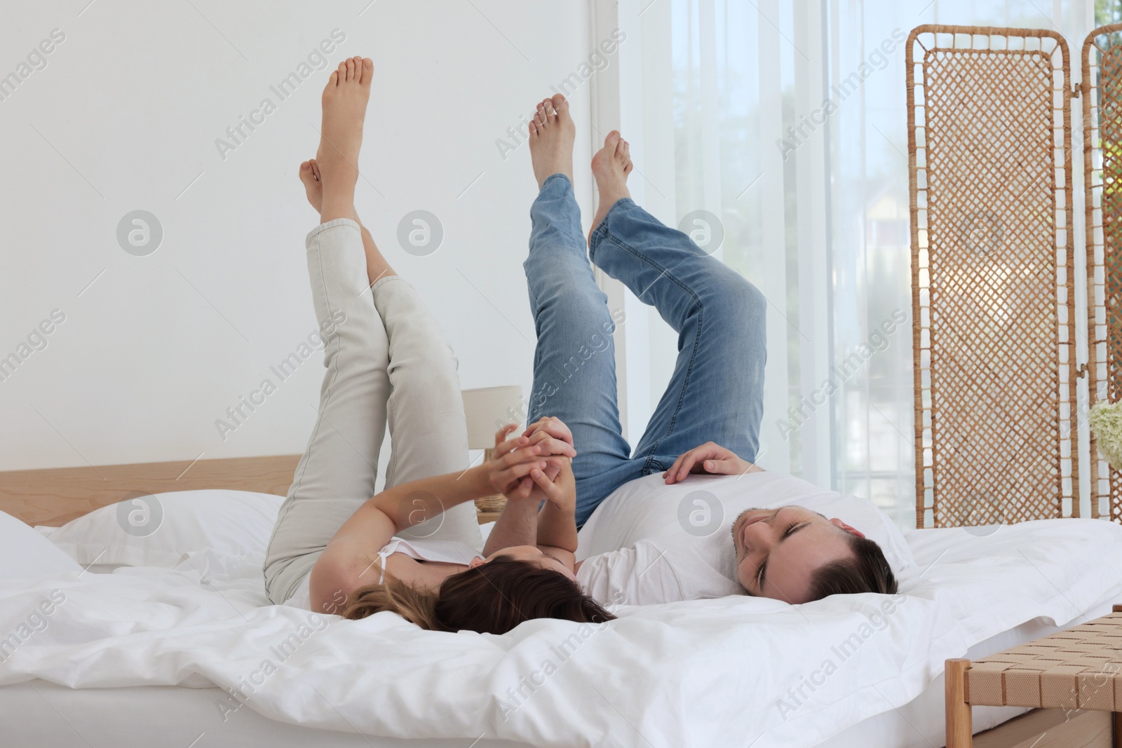 Photo of Lovely couple spending time together on bed at home