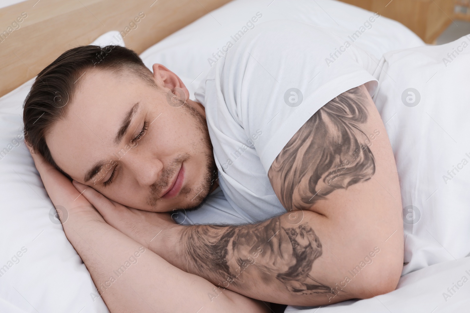 Photo of Bedtime. Handsome man sleeping in bed indoors