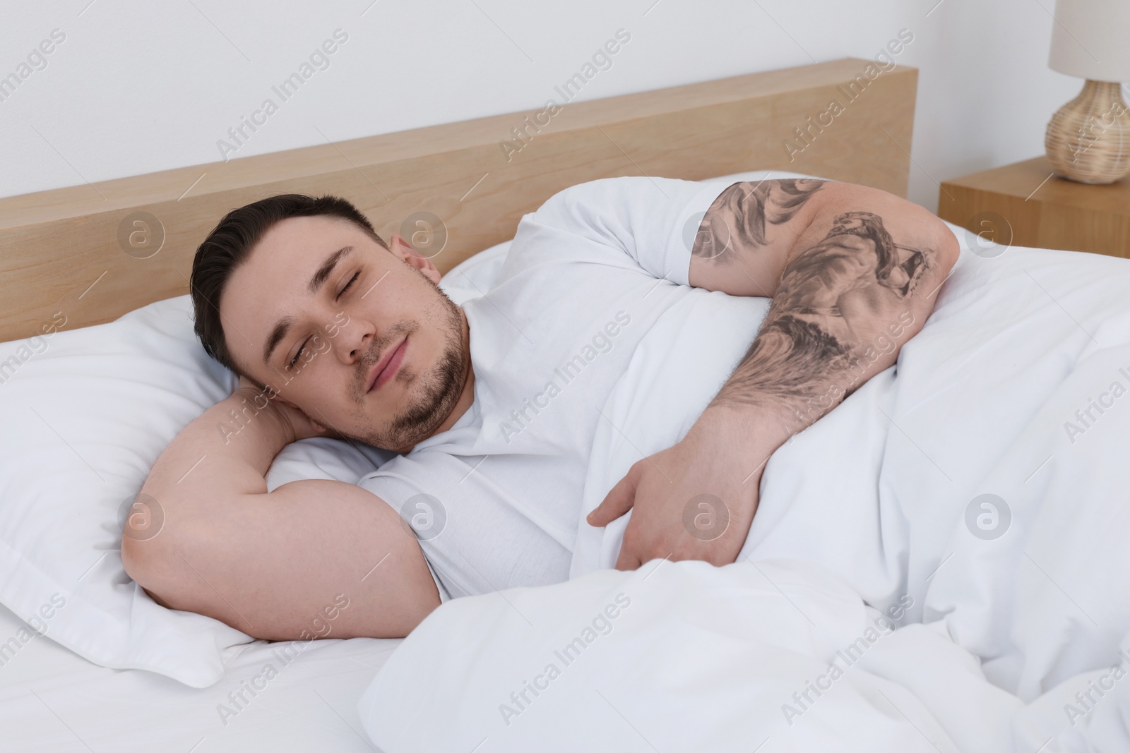 Photo of Bedtime. Handsome man sleeping in bed indoors