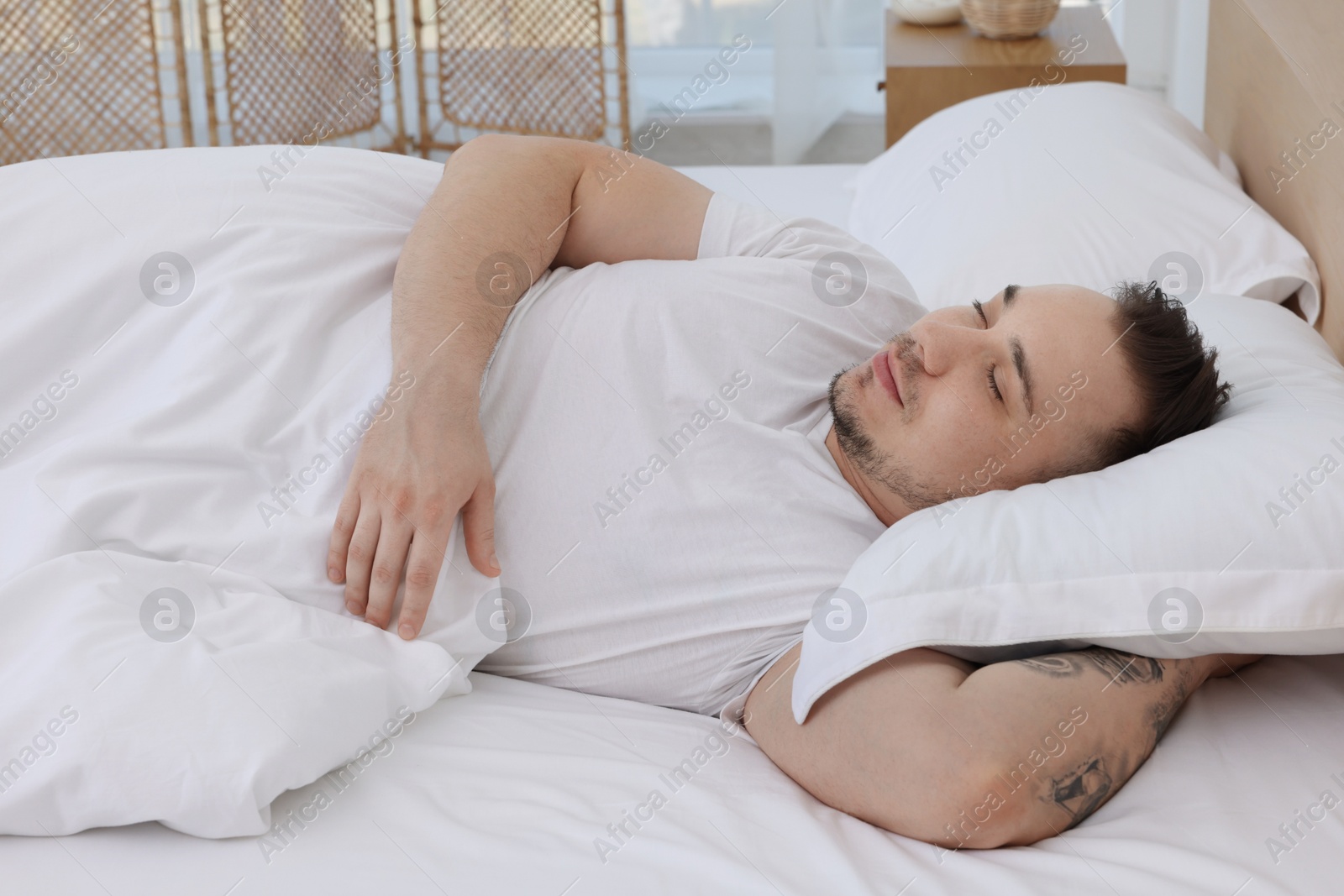 Photo of Bedtime. Handsome man sleeping in bed indoors