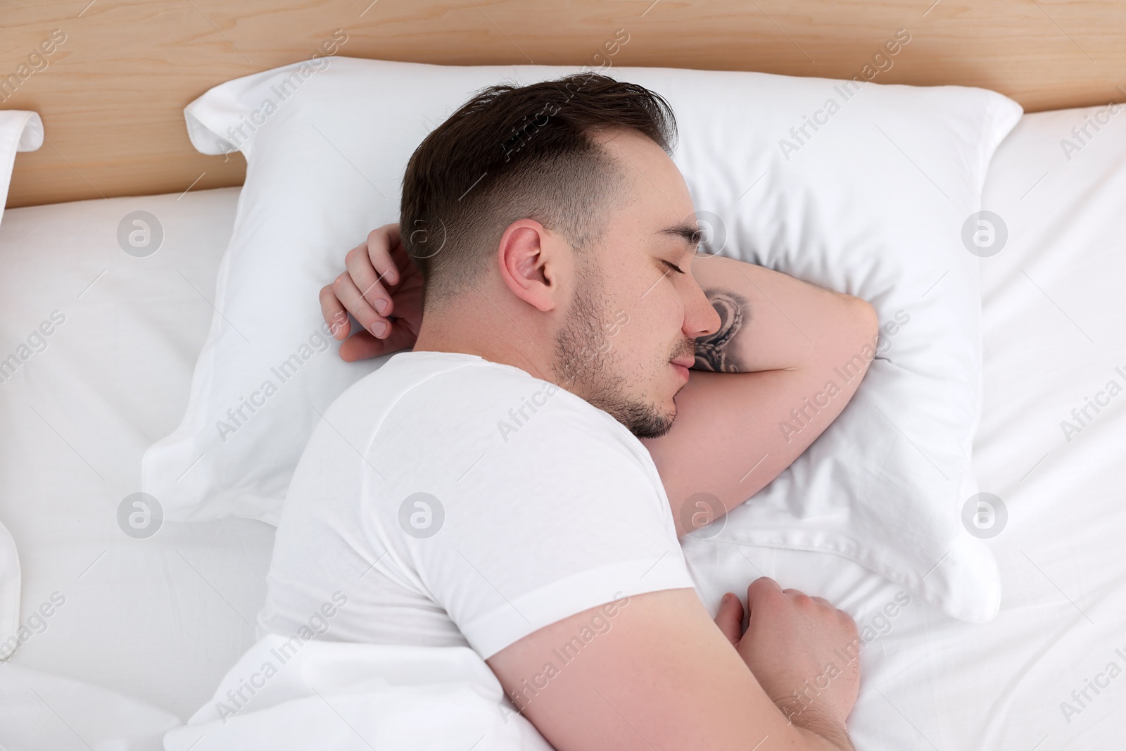 Photo of Bedtime. Handsome man sleeping in bed indoors