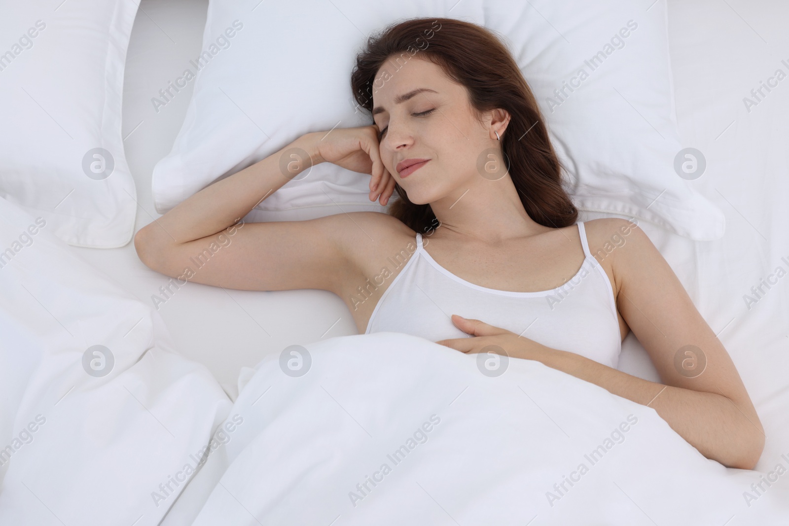 Photo of Bedtime. Woman sleeping in bed at home, above view